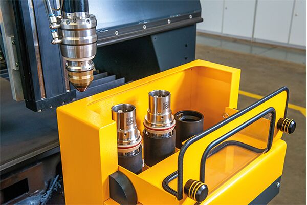 Plasmabrenner über einer gelben Aufnahmestation des Q-Torch Auto Change Systems mit mehreren austauschbaren Brennerköpfen.